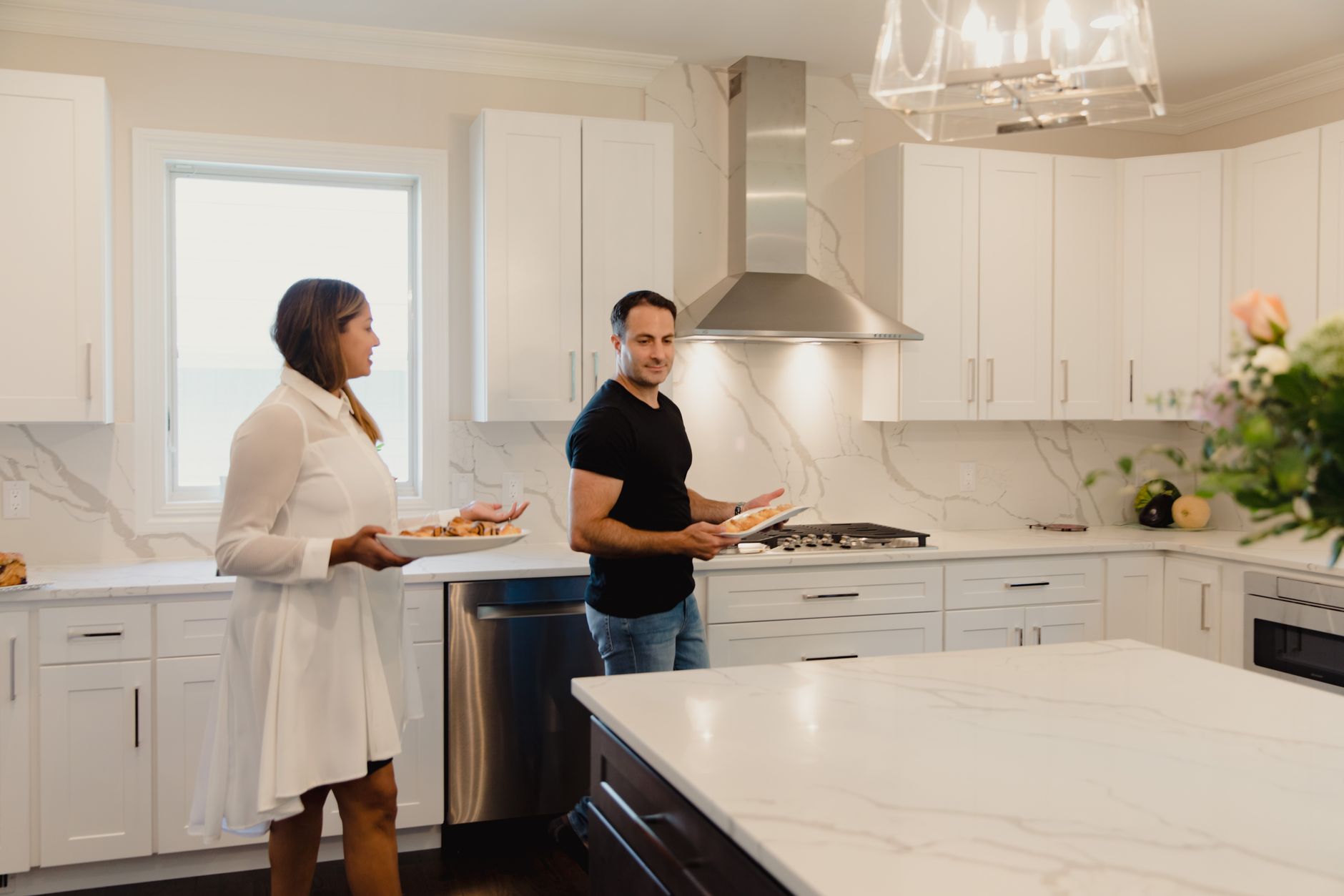 A joyful couple prepares food in a bright, modern kitchen, enjoying each other's company